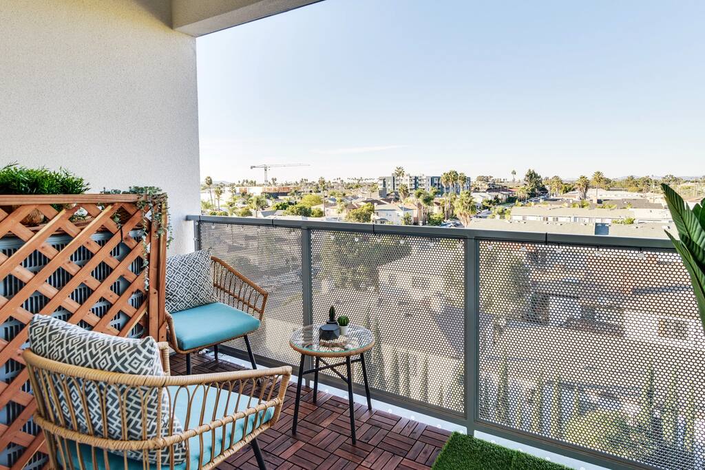 [Balcony] - two chairs, side table, city and mountain views, solar-powered string lights